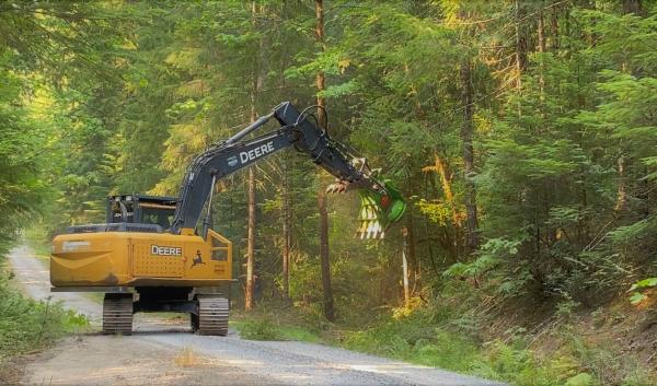 Excavator clears roadside vegetation for a fire break during the Cedar fire on the Willamette Valley National Forest. 