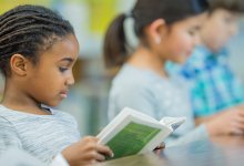 Photo of elementary students reading book in class