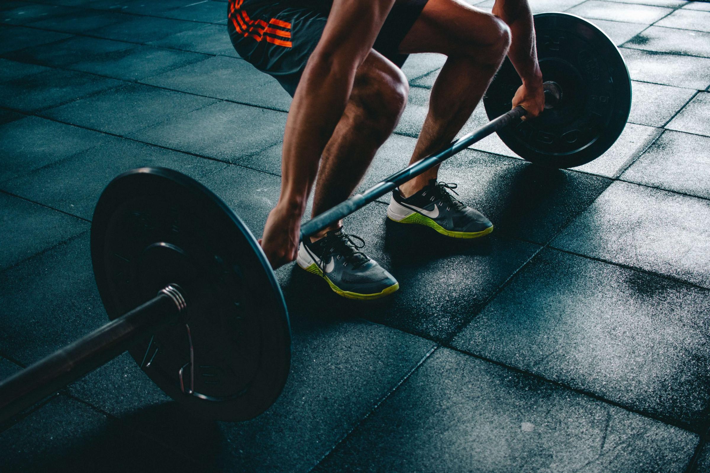 Person squatting down to pick up a barbell