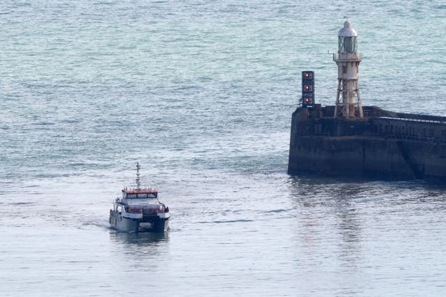 A group of people thought to be migrants are brought in to Dover (PA)