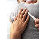 image of woman holding a pregnancy test