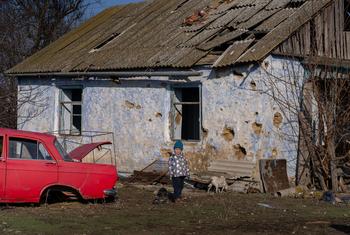 Roma, 4, stands in front of his destroyed home in Kobzartsi, Mykolaiv region