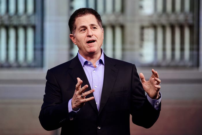 Michael Dell speaks in a black suit, gesturing with his hands.