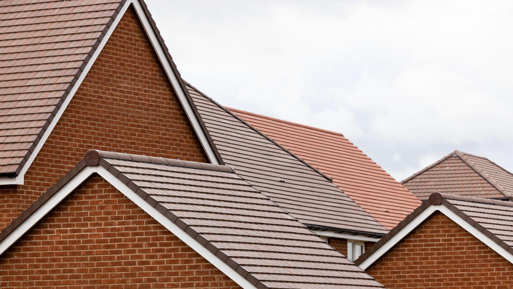 A stock image of multiple brick houses and their roofs