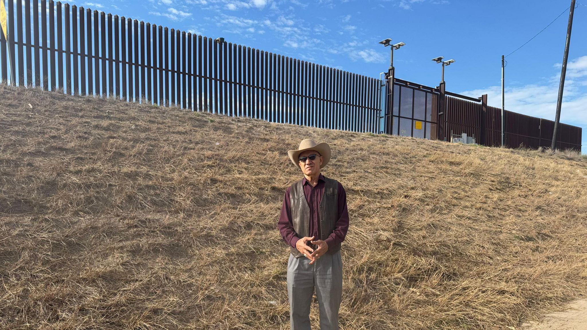 Demesio Guerrero standing by the border wall in Hidalgo, Texas. 