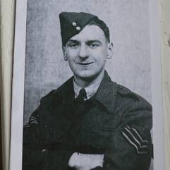 A photo of Bernard Morgan when he was a veteran in the Second World War. The photo is black and white and in it, Mr Morgan smiles at the camera while wearing his military uniform and cap.