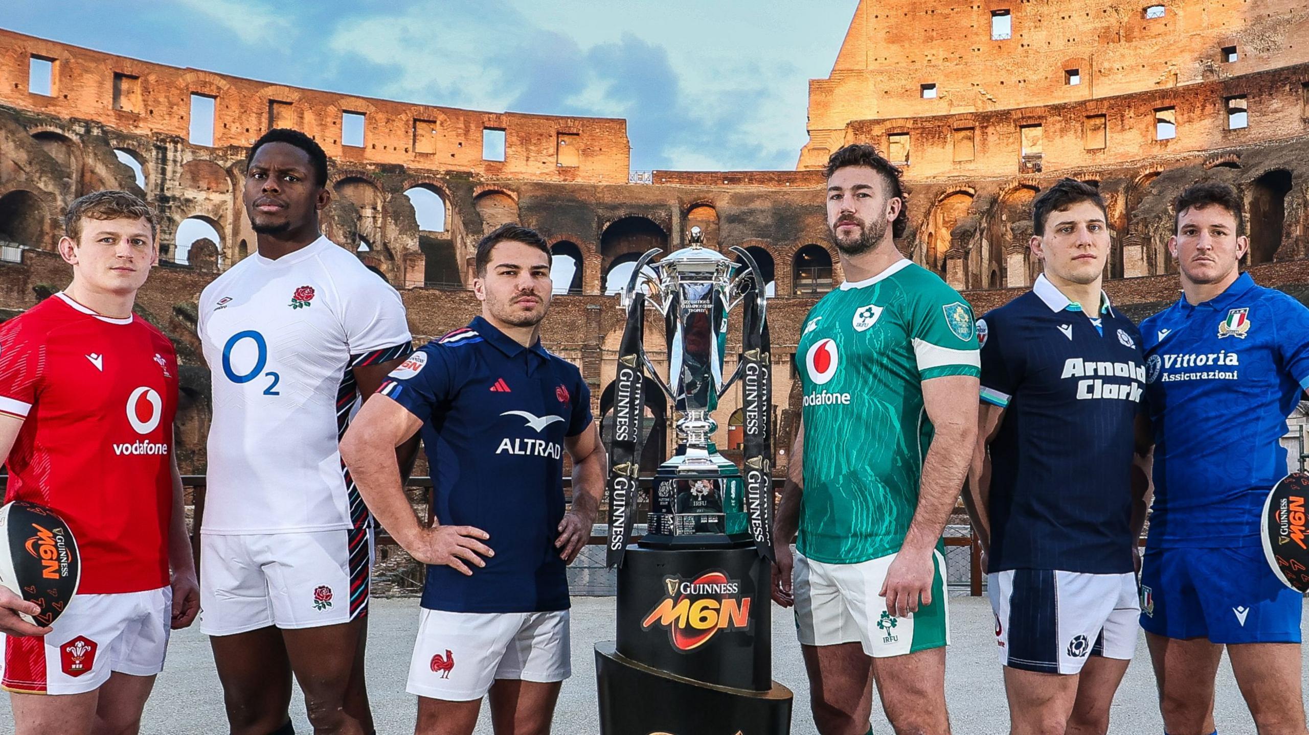 Jac Morgan of Wales, Maro Itoje of England, France's Antoine Dupont, Ireland skipper Caelan Doris, Scotland's co-captain Rory Darge and Italy's Michele Lamaro pose beside the Men's Six Nations trophy at the Colosseum in Rome