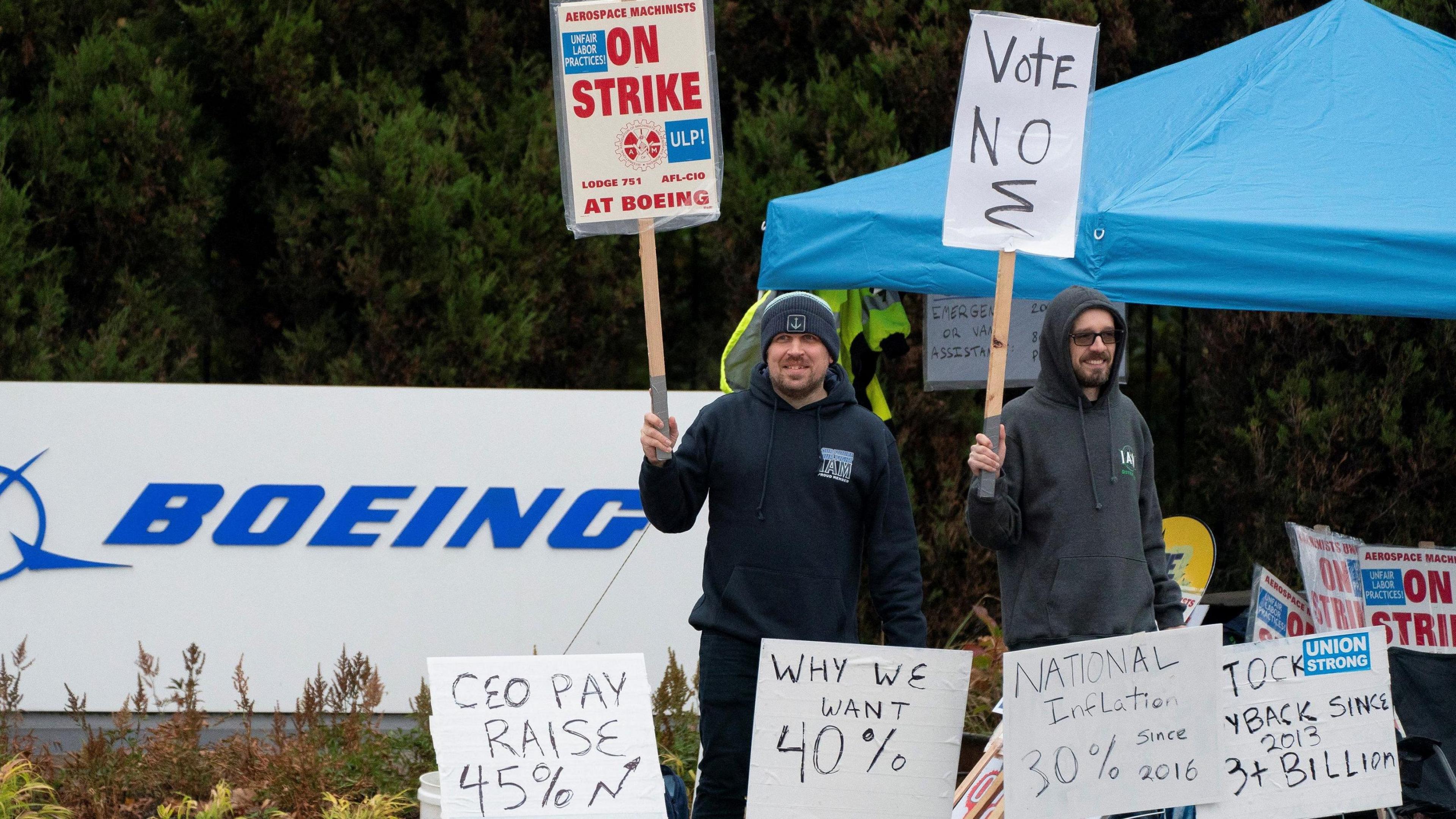 Striking Boeing workers hold signs on a picket line near the entrance to a Boeing production facility in Renton, Washington.