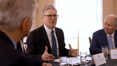 Keir Starmer sitting at a table speaking at a meeting