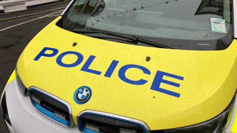 A police car with the word police against a yellow background.