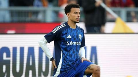 Dele Alli on one knee stretching in a Como kit