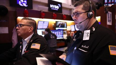 Two stock market traders in the US look at computer screens