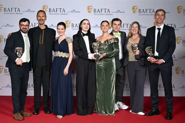 The cast and crew of best comedy winner Such Brave Girls pose for the cameras with their Bafta trophies