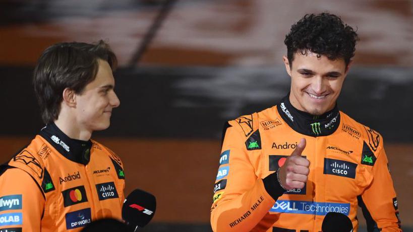 Lando Norris gives the thumbs-up sign while stood next to Oscar Piastri at the F1 season launch event