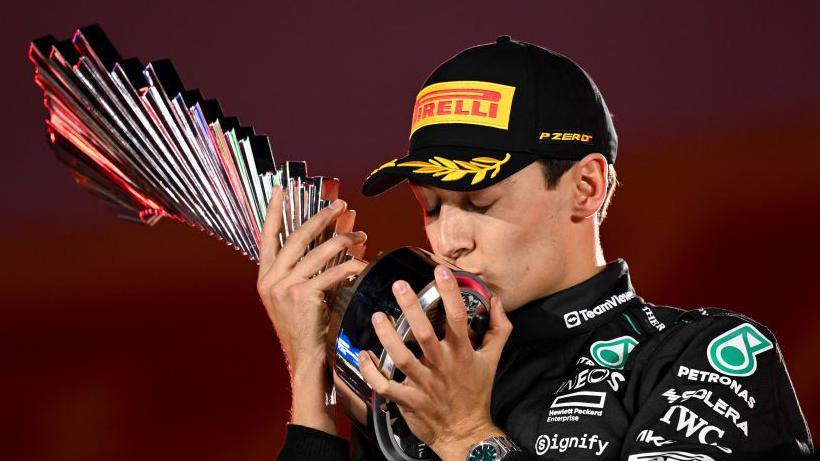 George Russell kisses the winners' trophy at the Las Vegas Grand Prix