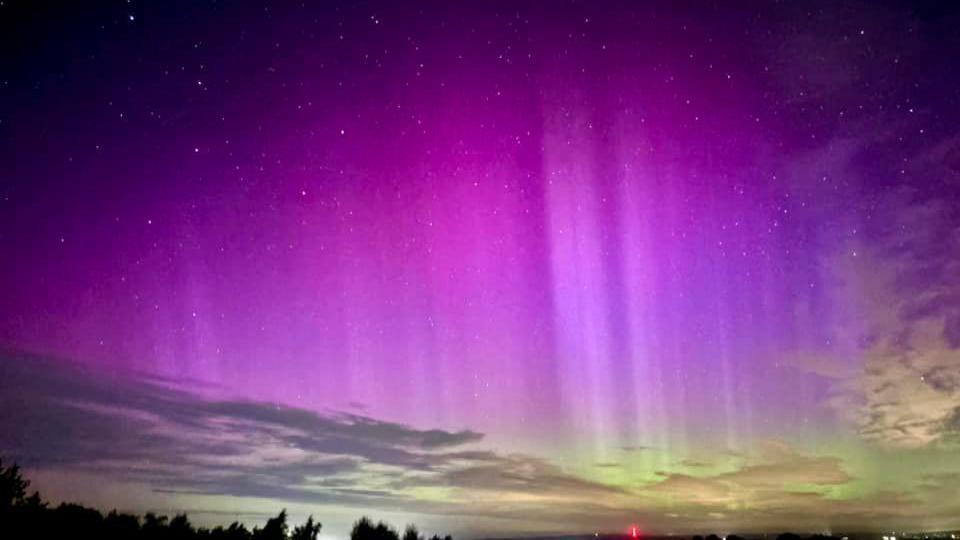 Northern Lights over Rurdean Hill in the Forest of Dean. The sky is a mixture of purple and light green