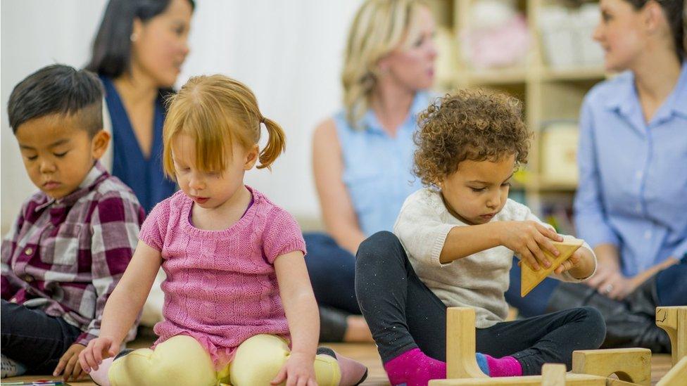 Young children playing in a library with their parents