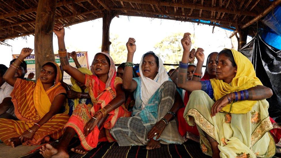 People protest under a thatched tent near Hariharpur