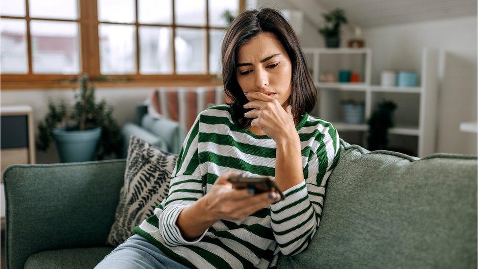 Woman looks at phone - stock shot