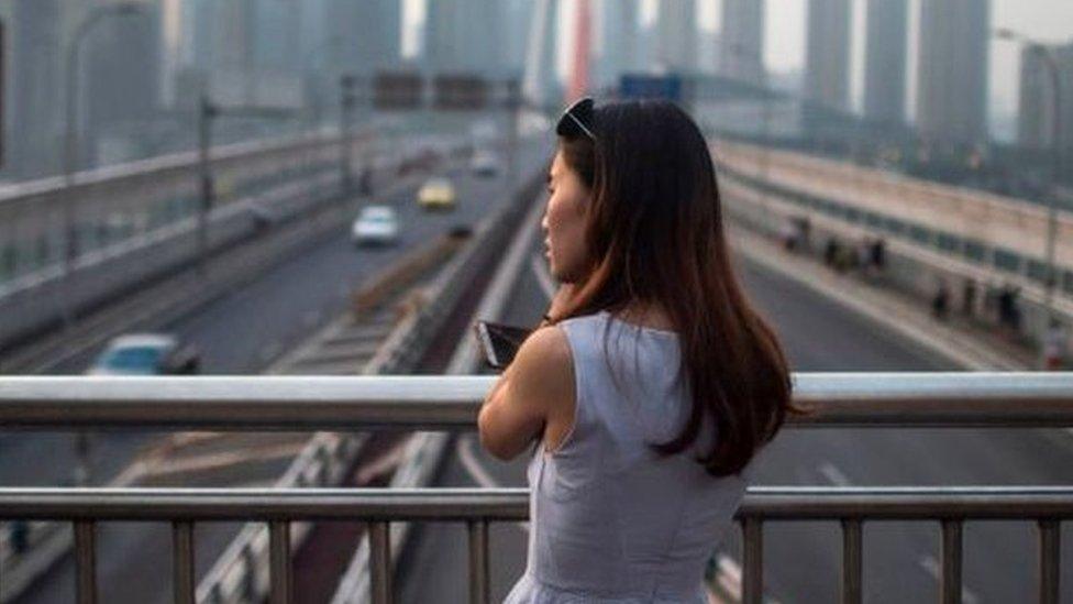 A young lady enjoys the view of the Yangtze river in Chongqing on May 31, 2017