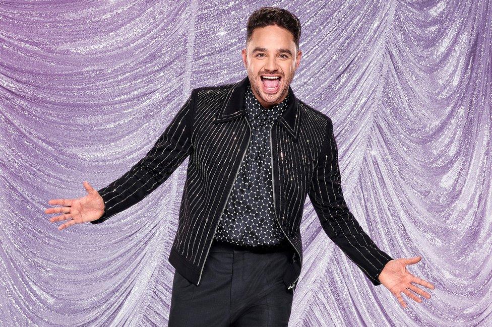 Adam Thomas wearing a black sparkly outfit