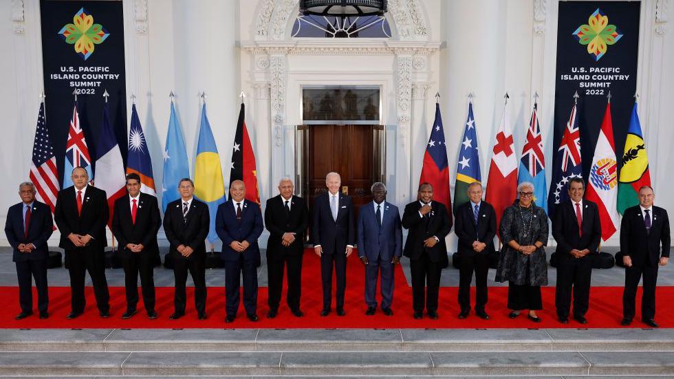 US President Joe Biden (C) and leaders from the Pacific Islands region pose for a photograph on the North Portico of the White House September 29, 2022 in Washington DC. Behind them is a row of flags of the various countries present.  