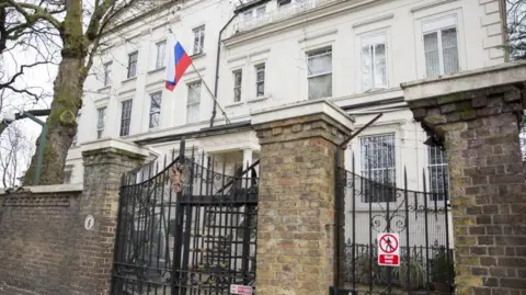 Getty Images External image of the Russian embassy building in London - a white building behind a stone fence with large black wired gate.