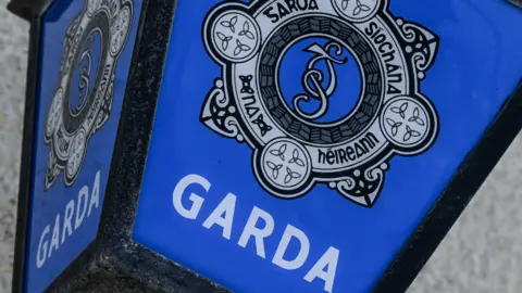 Close shot of blue Garda sign with badge