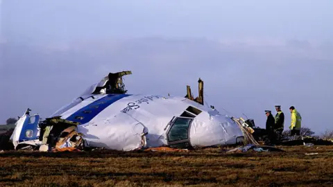 Getty Images The wreckage of flight Pam Am 103 in Lockerbie. Police officers inspect the area around the nose of the aircraft.