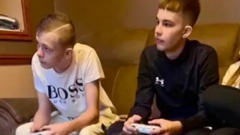 Family handout Max Dixon and Mason Rist sat next to eachother playing video games