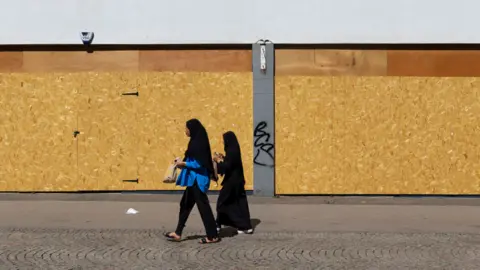 Getty Images Women walking on a neglected high street