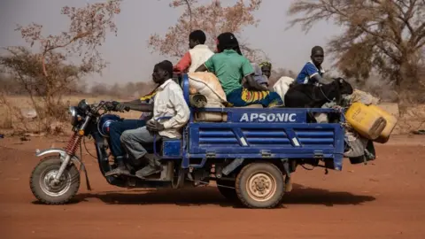 Getty Images People with their belongings on a vehicle flee their villages, on the road from Barsalogho to Kaya on January 27, 2020