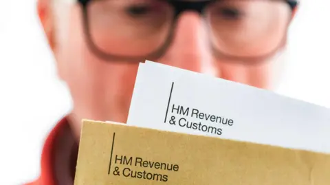 A man looking at a letter from HMRC