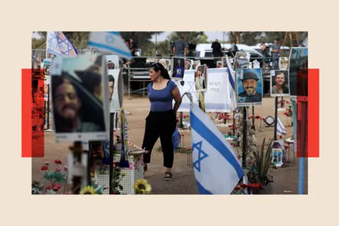 Reuters A woman stands among tributes at the Nova festival site, honouring victims who were killed or kidnapped on October 7. The area is surrounded by photos and flowers