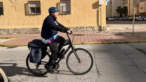 A man rides a bicycle through the streets of southern Spain.