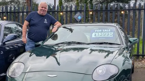 Andrew Jenkins Andrew Jenkins, film producer, stands next to his green Aston Martin car