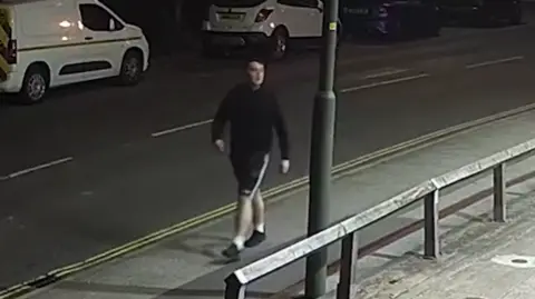 Derbyshire Police An image of Paul Jinks walking through a street in Long Eaton whilst stalking a woman