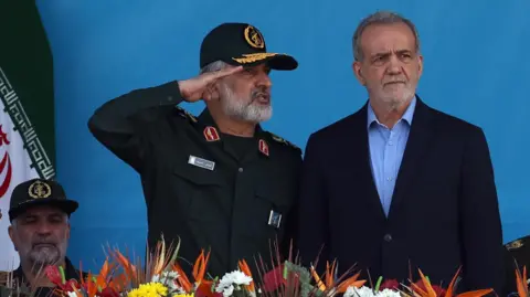 EPA Iranian President Masoud Pezeshkian (R) and the commander of the Islamic Revolution Guard Corps' Aerospace Force, Amir Ali Hajizadeh (L), attend a military parade in Tehran, Iran (21 September 2024)