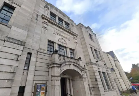 A picture of the front of a grand grey-coloured building