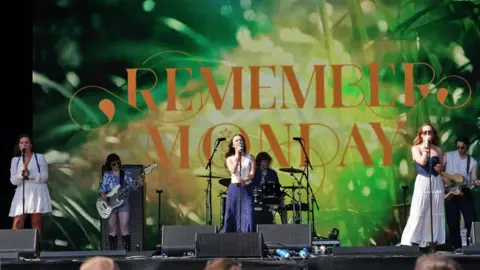 Dave Hogan/Hogan Media/Shutterstock Remember Monday on a festival stage with a large colourful backdrop showing their name