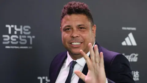 Former Brazil striker Ronaldo waves to the camera at a Fifa awards event