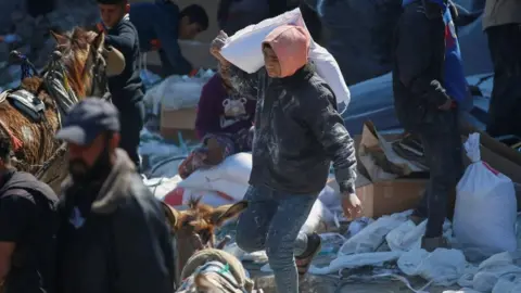 A Palestinian boy carries a bag with aid supply provided by the UN's Palestinian refugee agency (Unrwa) in northern Gaza Strip. Photo: 2 March 2025