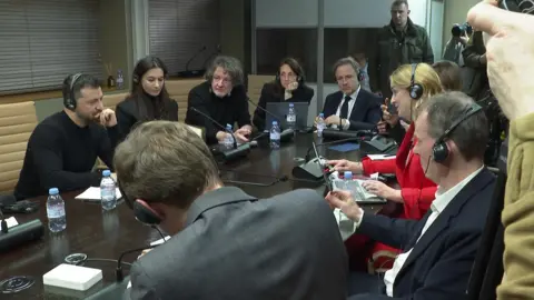 Zelensky surrounded by members of the press, including the BBC's Laura Kuenssberg, at a press conference a