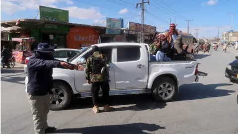 FAYYAZ AHMED/EPA-EFE/REX/Shutterstock Pakistani security officials check people at a roadside checkpoint in Quetta, the provincial capital of Balochistan province, Pakistan, 17 January 2024