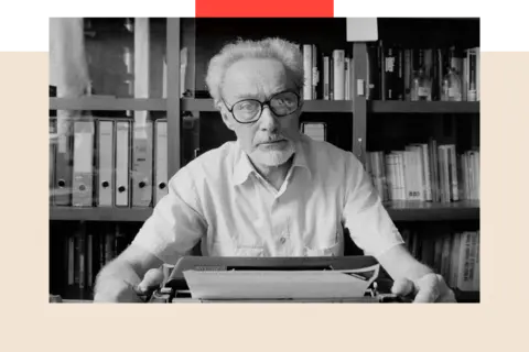 Getty Images Author, Primo Levi, in 1986, sitting in front of a bookshelf with a typewriter