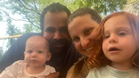 Family handout A family photo taken outside showing Yarden and Shiri Bibas holding their baby and toddler