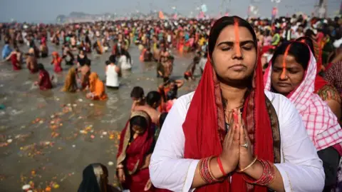 Image shows Hindu devotees taking a dip and pray ahead of the second sacred bathing ritual during the Kumbh Mela festival in Prayagraj, northern state of Uttar Pradesh, India, 28 January 2025