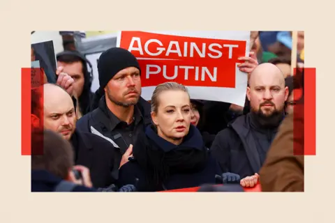 Reuters Vladimir Kara-Murza (L) and Yulia Navalnaya (C) attend an anti-war demonstration in Berlin, Germany and stand in front of a poster that reads 'Against Putin'.