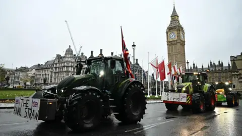 Getty Images Tractors are seen driving past Big Ben in London during a protest over the proposed farm inheritance tax. 