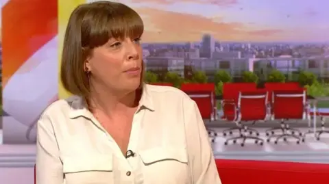 The MP is sat in the BBC Breakfast studio wearing a white shirt with brown hair in a bob style